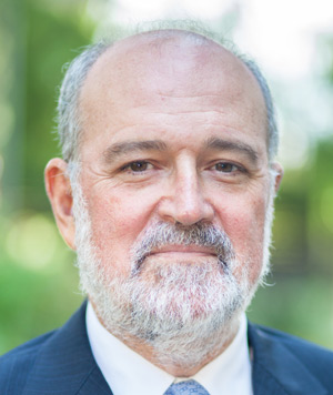 A picture of Joan Ricart against a blurry green background.