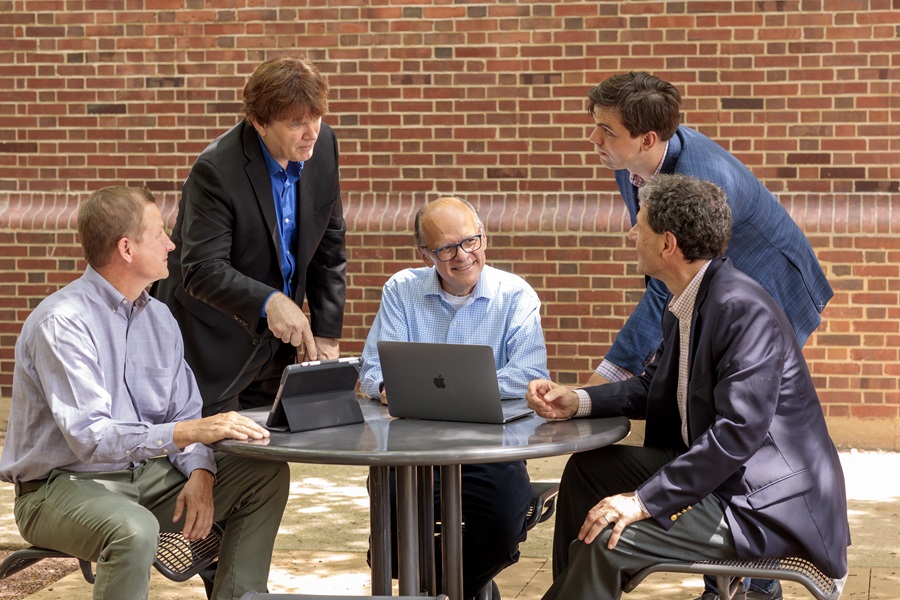 Group of 5 scholars engage in conversation
